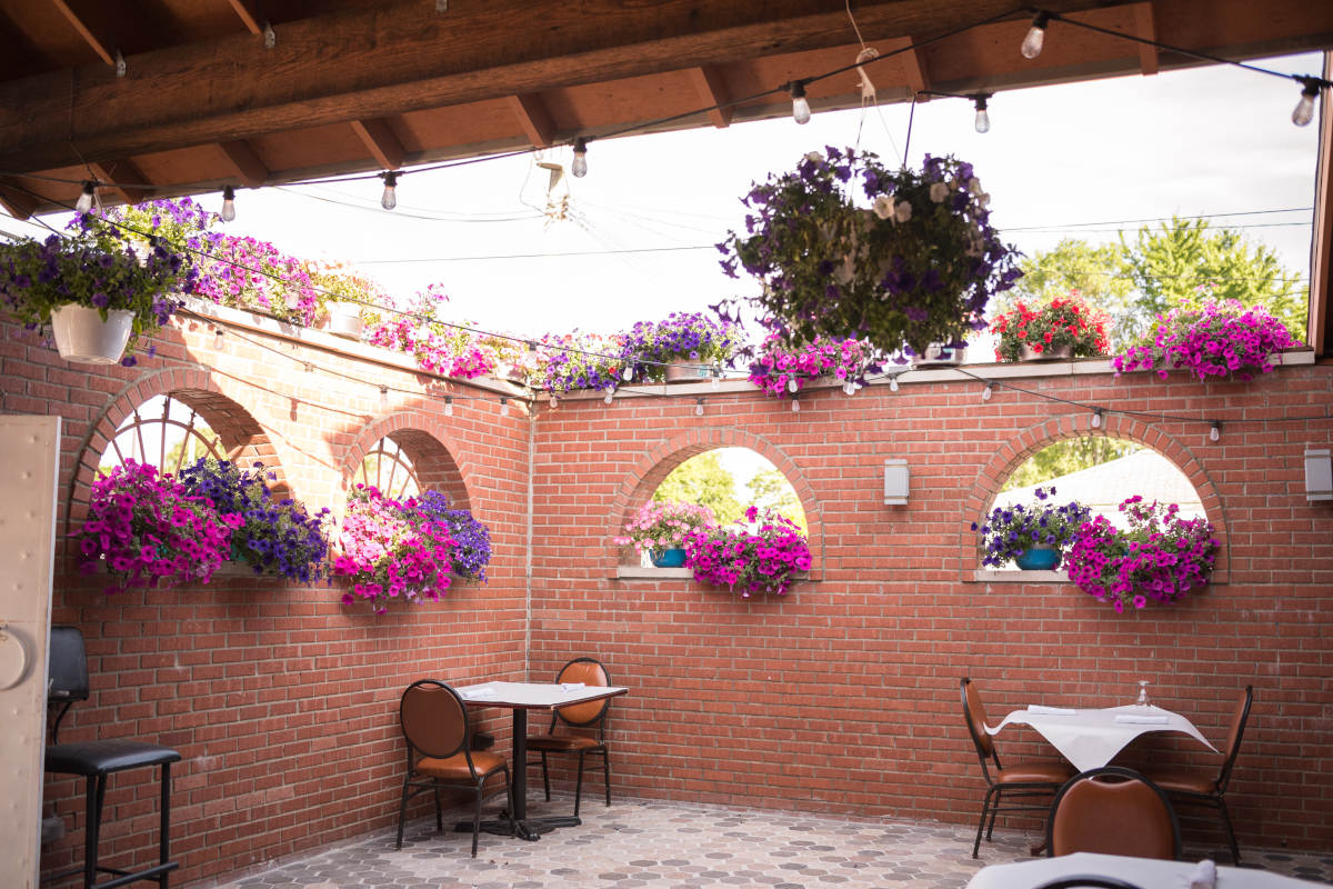 Restaurant exterior, tables for two, flowers decorations on the wall